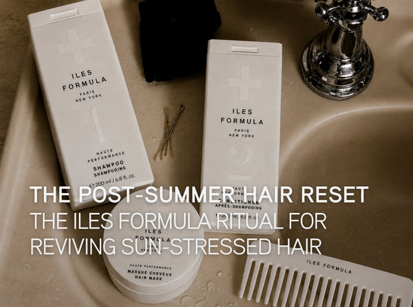 Iles Formula Shampoo, Conditioner, Hair Mask and wide-tooth comb arranged on a wet marble sink, illustrating the post-summer hair reset ritual for reviving sun-stressed hair.