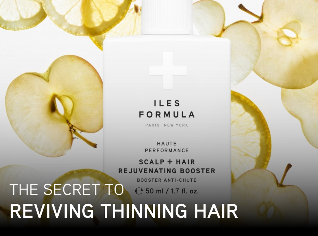 Bottle of Iles Formula Scalp + Hair Rejuvenating Booster placed against a background of apple slices, with text overlay that reads: “The secret to reviving thinning hair.”