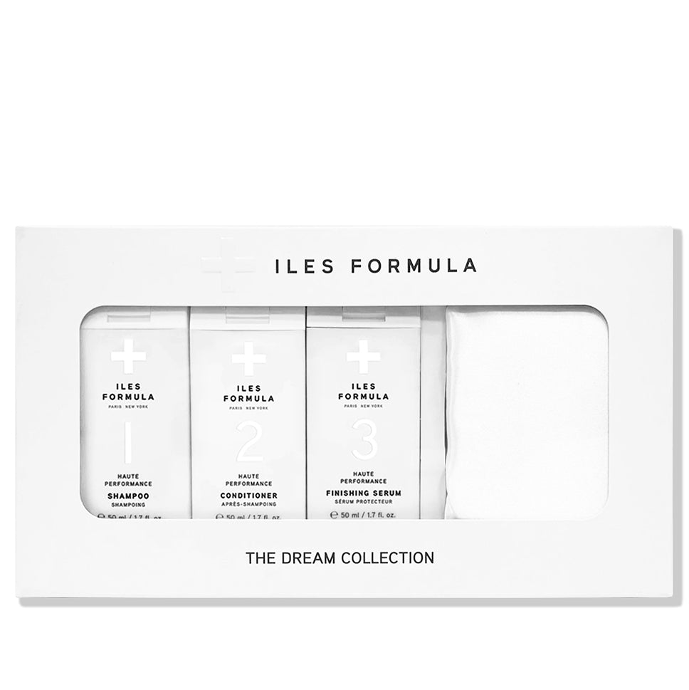 A white gift box labeled 'ILES FORMULA - THE DREAM COLLECTION' containing travel-sized hair care products including shampoo, conditioner, and serum, alongside a white silky pillowcase.