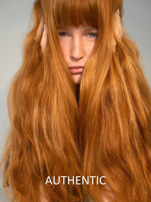 Person with long, wavy red hair on a plain background with 'AUTHENTIC' text.