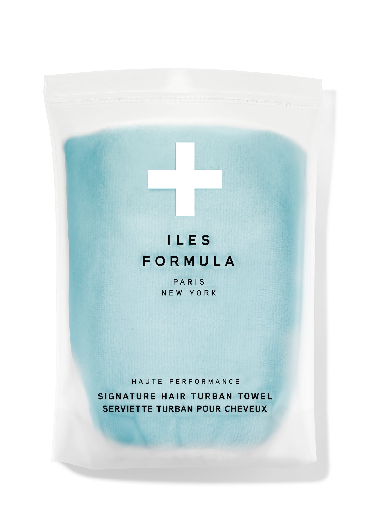 A packaged hair turban product in a clear plastic bag with a label that reads 'ILES FORMULA' and 'LIMITED EDITION SPA BLUE'. The brand logo includes a cross and the text 'PARIS - NEW YORK'.