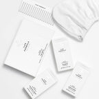 Limited Edition Travel Edit Flat Lay; The Minis Box, Mini Shampoo, Mini Conditioner, Mini Finishing Serum, Conditioning Distribution Comb, and Hair Turban Towel